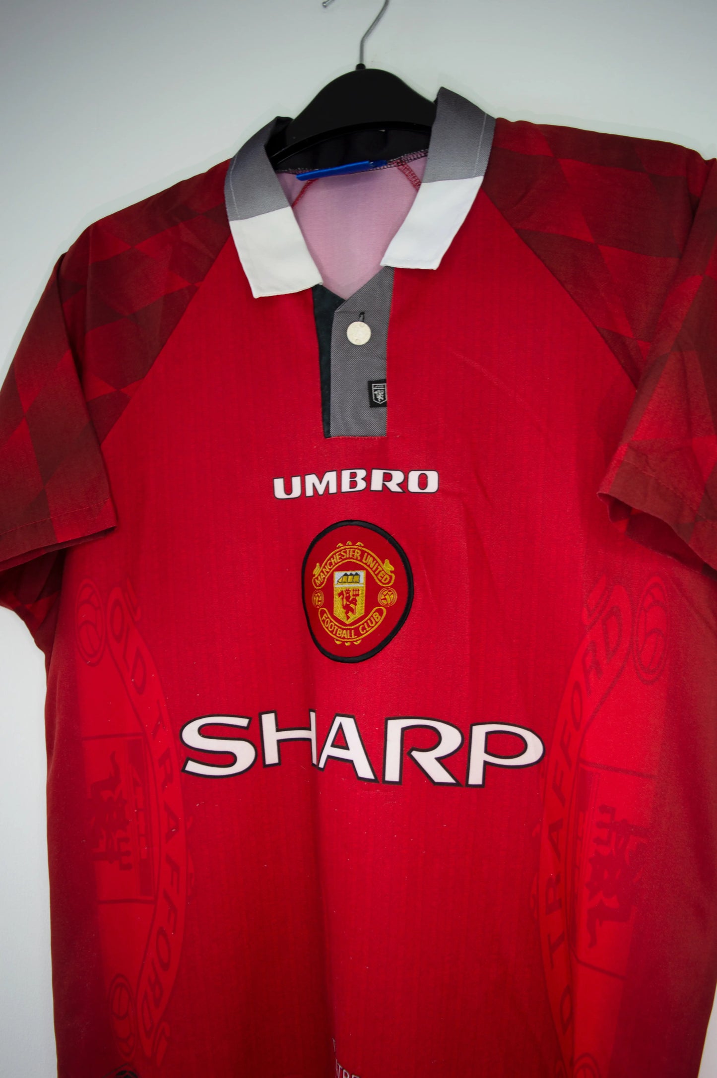 Maillot domicile de Manchester United de la saison 1996-1998. On peut retrouver l'équipementier umbro et le sponsor sharp