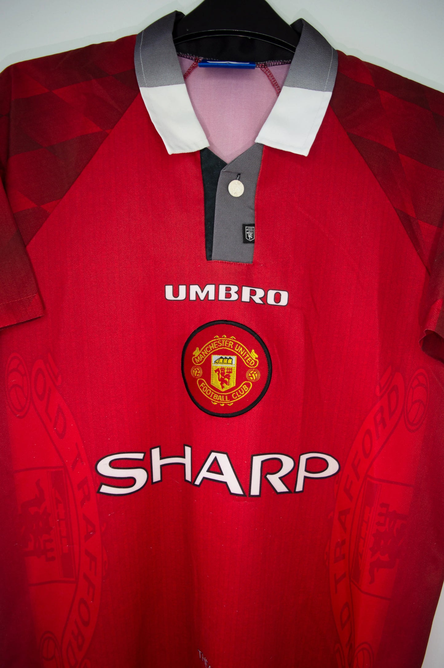 Maillot domicile de Manchester United de la saison 1996-1998. On peut retrouver l'équipementier umbro et le sponsor sharp