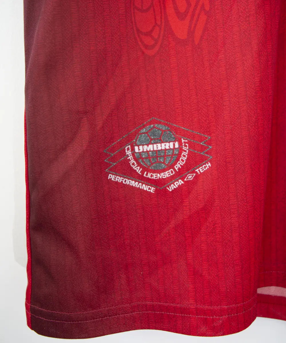 Maillot domicile vintage rouge de manchester united de la saison 1996-1998. On peut retrouver l'équipementier umbro et le sponsor sharp