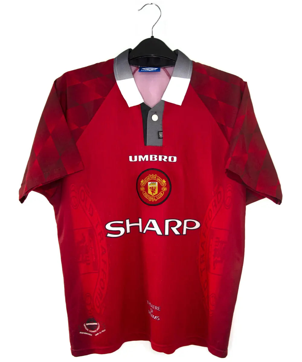 Maillot domicile de Manchester United de la saison 1996-1998. On peut retrouver l'équipementier umbro et le sponsor sharp