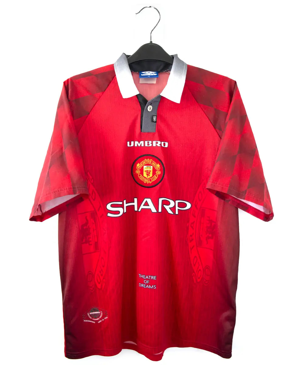 Maillot domicile vintage rouge de manchester united de la saison 1996-1998. On peut retrouver l'équipementier umbro et le sponsor sharp