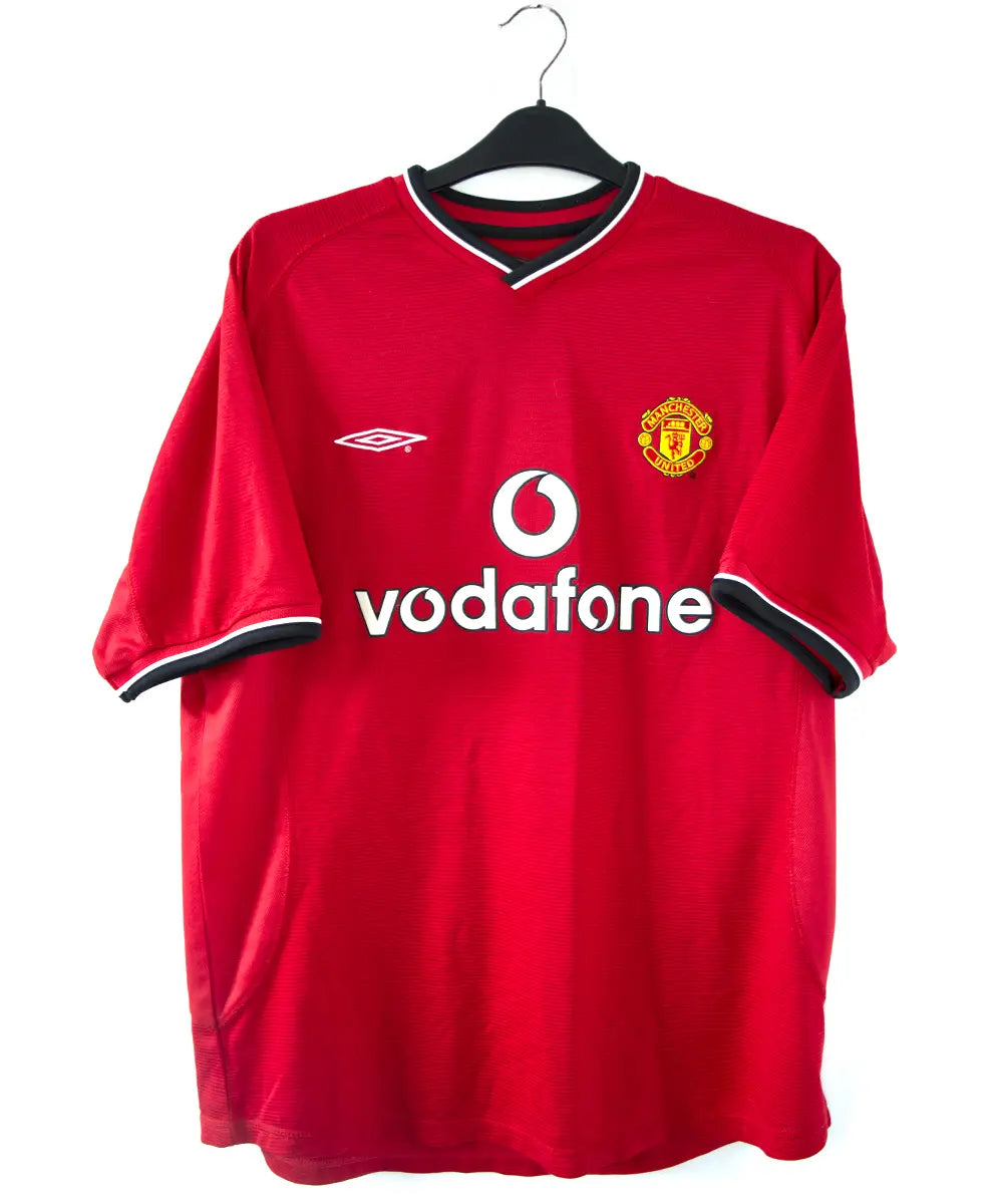 Maillot domicile rouge et noir de manchester united édité lors de la saison 2000-2002. On peut retrouver l'équipementier umbro et le sponsor vodafone