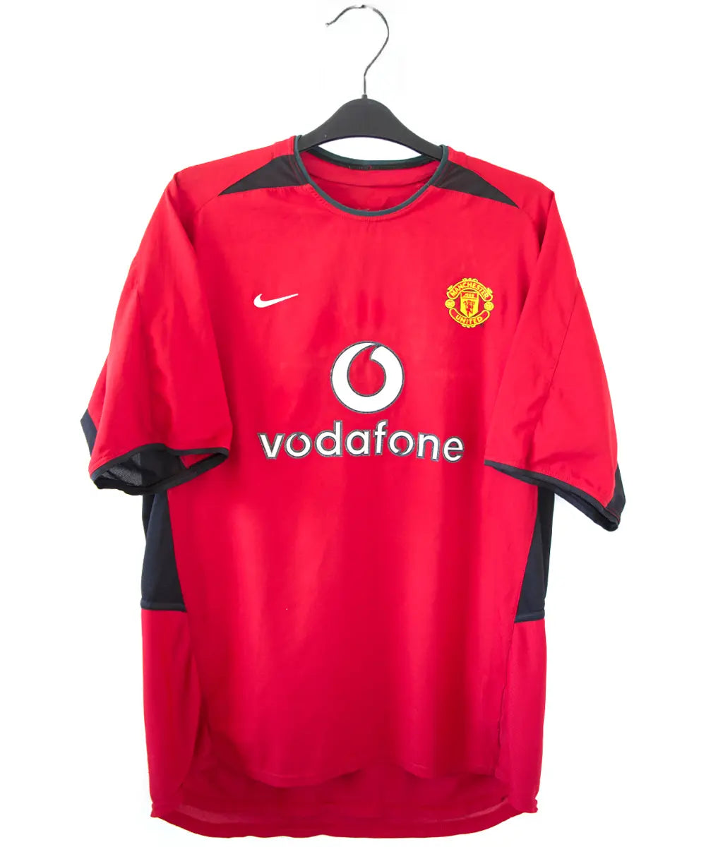 Maillot domicile rouge et noir de Manchester United de la saison 2002-2004. On peut retrouver l'équipementier nike et le sponsor Vodafone. Le maillot est floqué du numéro 7 Cristiano Ronaldo