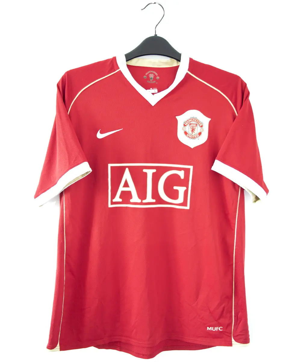 Maillot domicile rouge de manchester united de la saison 2006-2007. Le maillot est floqué du numéro 7 cristiano ronaldo. Sur cette photo on peut voir le devant du maillot avec le sponsor AIG et l'équipementier nike