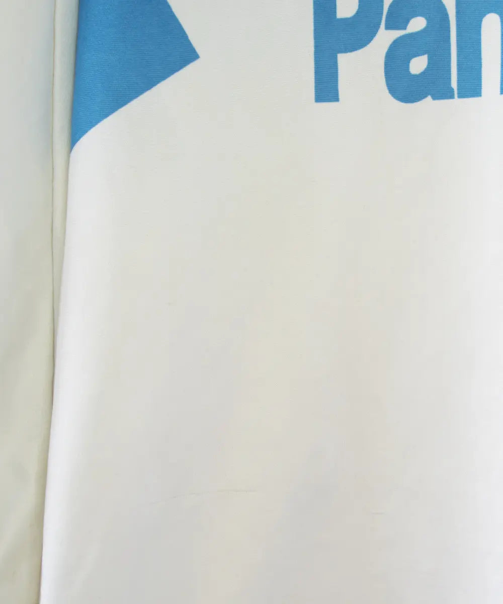 Maillot domicile blanc et bleu de l'om de la saison 1991-1992. On peut retrouver l'équipementier adidas et le sponsor Panasonic.