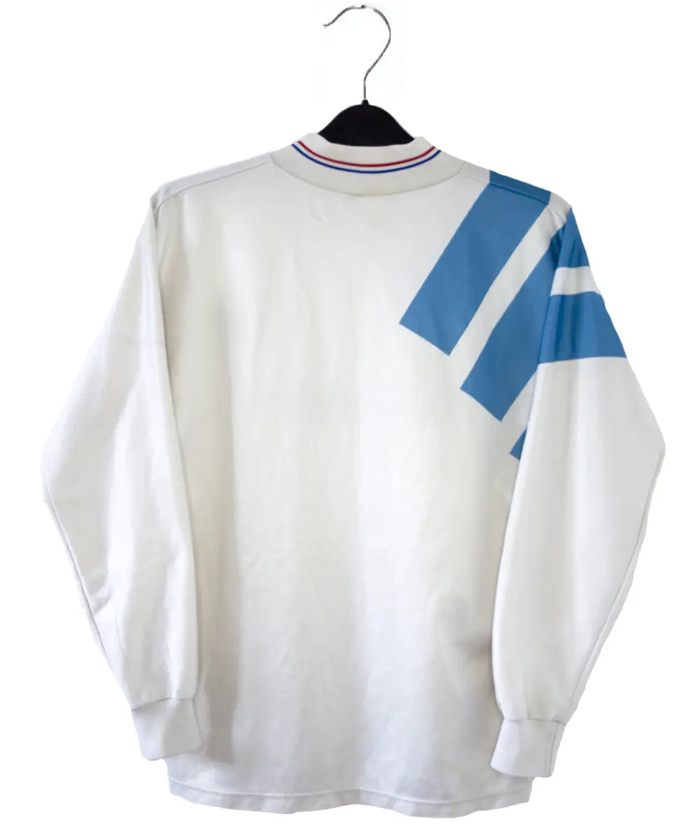 Maillot domicile blanc et bleu de l'om de la saison 1991-1992. On peut retrouver l'équipementier adidas et le sponsor Panasonic.