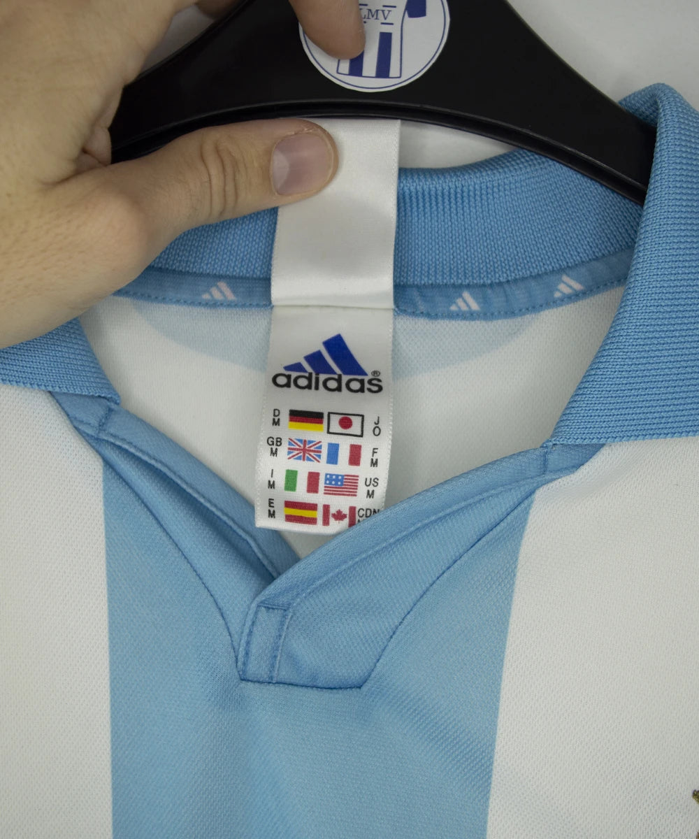 Maillot de foot vintage de l'om de la saison 2000-2001. Le maillot est de couleur blanc et bleu. On peut retrouver l'équipementier adidas et le sponsor ericsson. Ils s'agit d'un maillot authentique