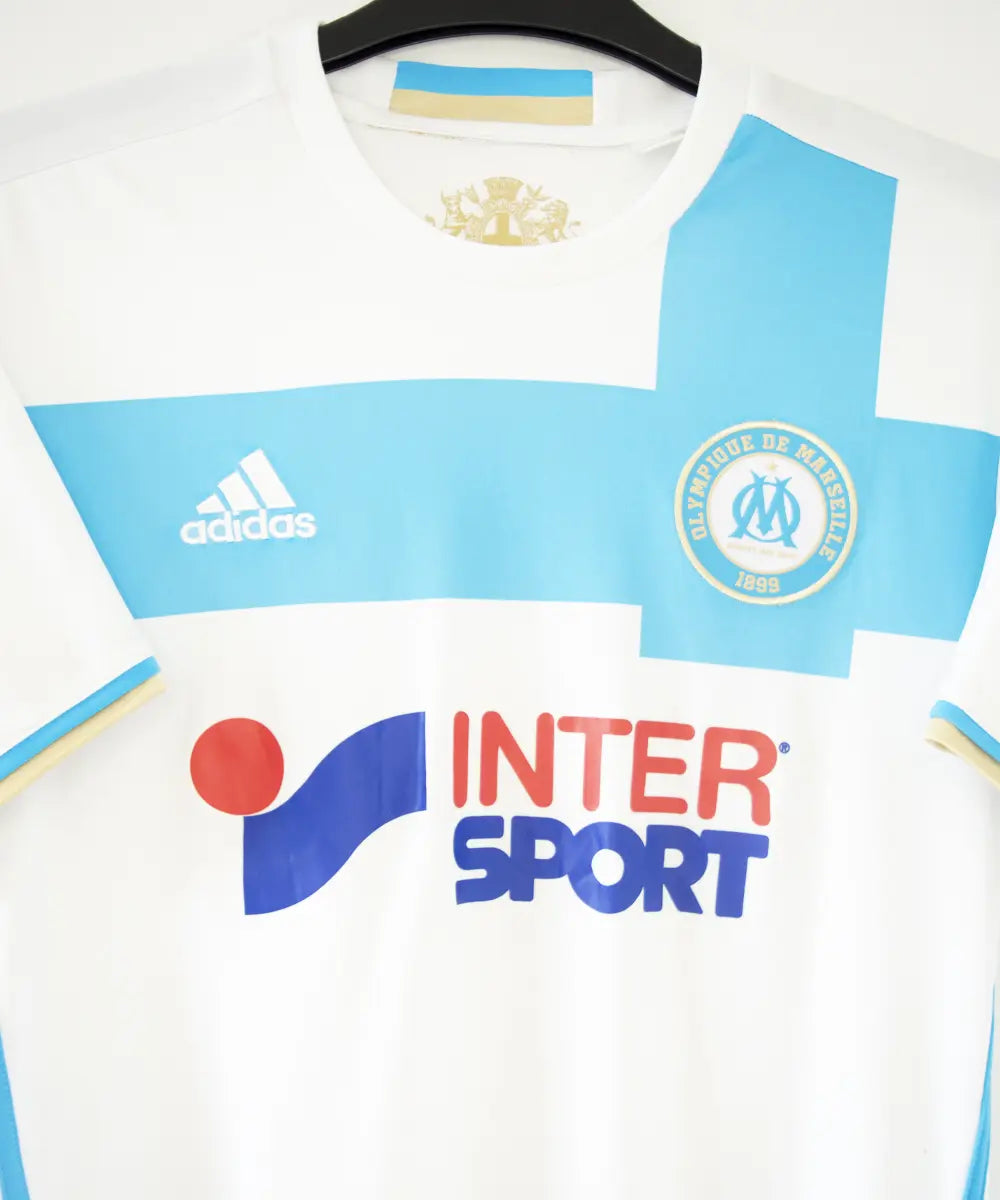 Maillot domicile OM 2016-2017 bleu et blanc. On peut retrouver l'équipementier adidas et le sponsor intersport