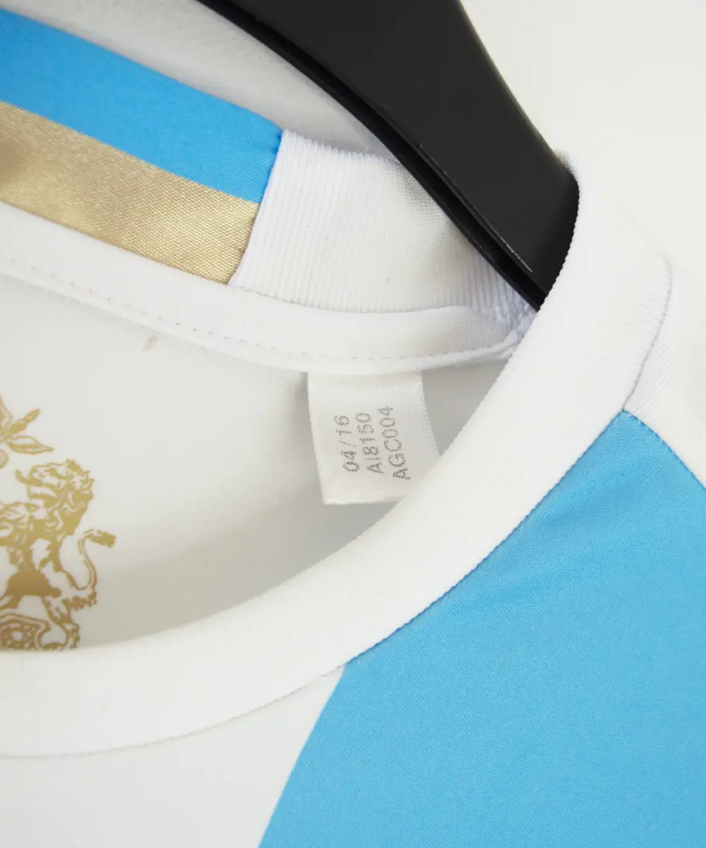 Maillot domicile OM 2016-2017 bleu et blanc. On peut retrouver l'équipementier adidas et le sponsor intersport. Sur cette photo on peut voir l'étiquette comportant les numéros AI8150