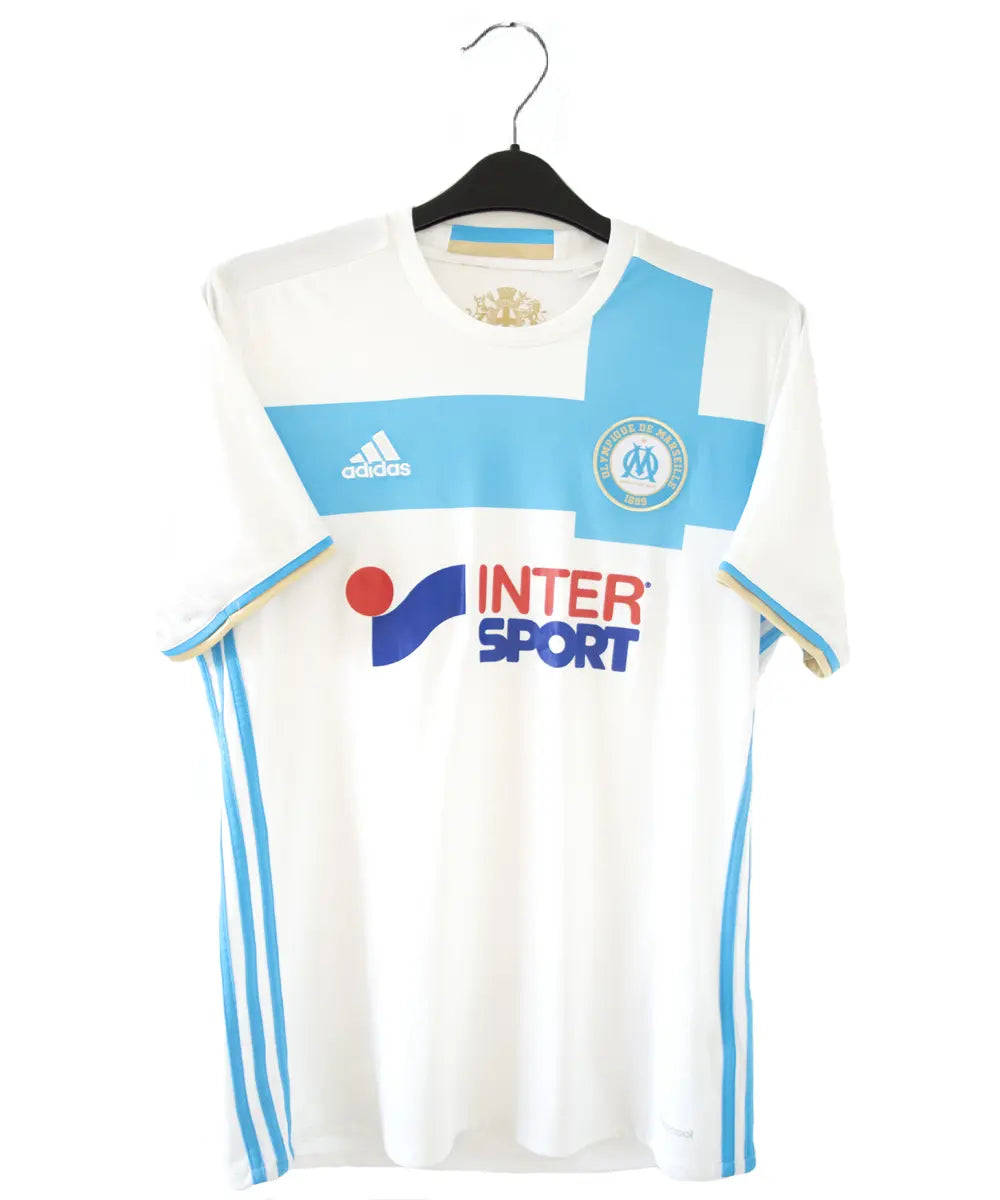 Maillot domicile OM 2016-2017 bleu et blanc. On peut retrouver l'équipementier adidas et le sponsor intersport