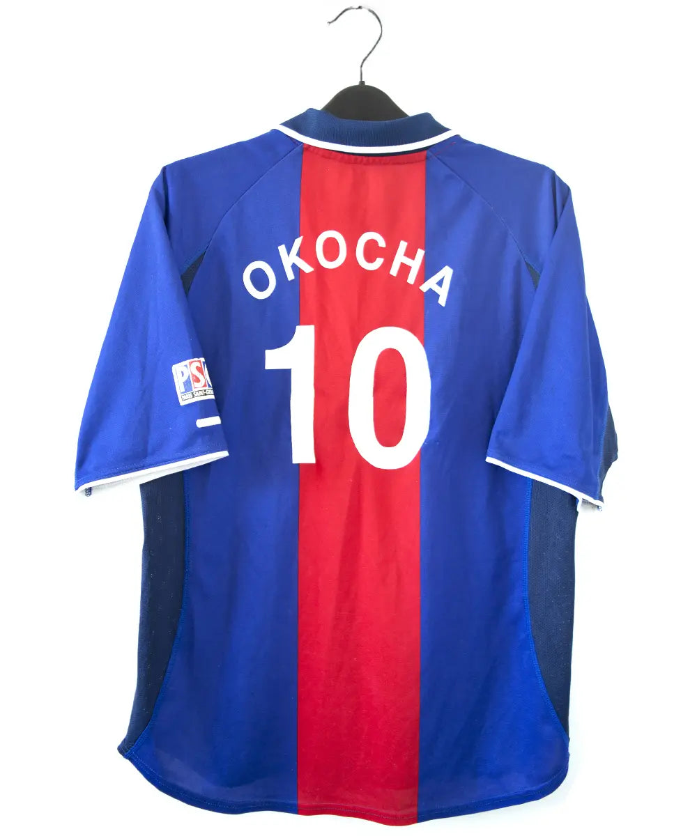 Maillot authentique domicile du PSG de la saison 2000-2001. Le maillot est de couleur bleu et rouge. On peut retrouver l'équipementier nike et le sponsor opel en feutrine. Le maillot est floqué du numéro 10 okocha. Sur cette photo on peut voir le maillot de dos