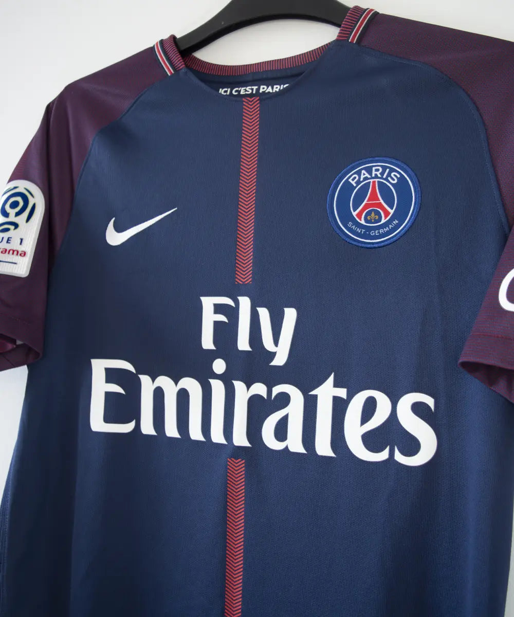 Maillot authentique du psg de la saison 2017-2018. Le maillot est de couleur bleu et rouge. On peut retrouver sur le maillot l'équipementier nike et le sponsor fly emirates et QNB. Le maillot est floqué du numéro 10 neymar. Sur cette photo on peut voir le devant du maillot de côté