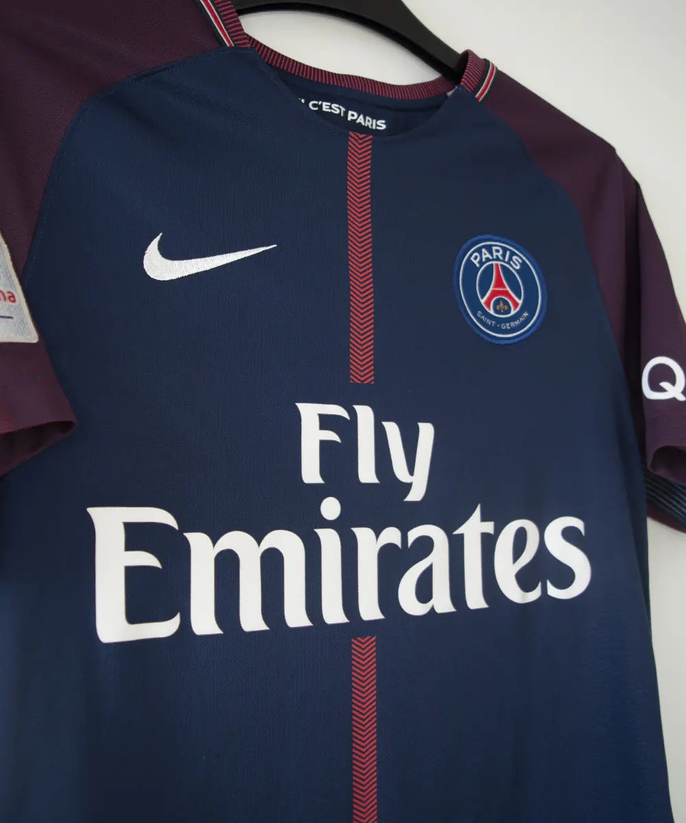 Maillot domicile bleu et rouge du psg de la saison 2017-2018. On peut retrouver l'équipementier nike et le sponsor fly emirates. Le maillot est floqué du numéro 10 Neymar