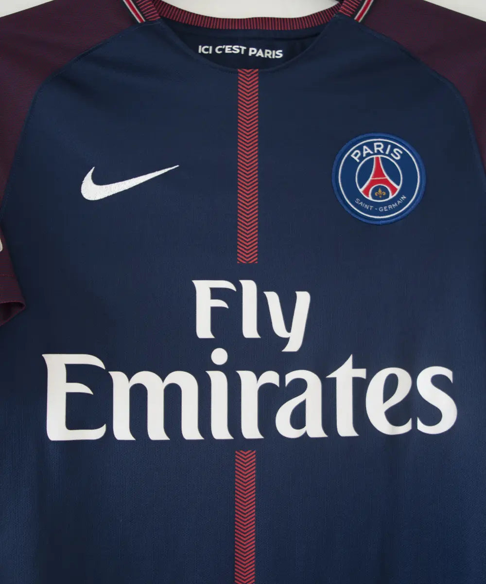 Maillot domicile bleu et rouge du psg de la saison 2017-2018. On peut retrouver l'équipementier nike et le sponsor fly emirates. Le maillot est floqué du numéro 10 Neymar