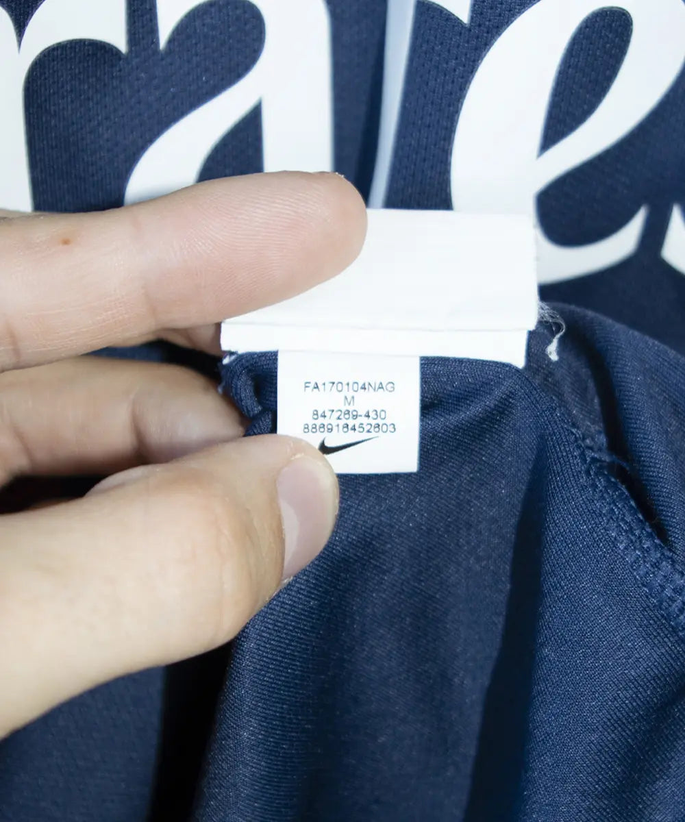 Maillot authentique du psg de la saison 2017-2018. Le maillot est de couleur bleu et rouge. On peut retrouver sur le maillot l'équipementier nike et le sponsor fly emirates et QNB. Le maillot est floqué du numéro 10 neymar. Sur cette photo on peut voir l'étiquette d'authenticité du maillot comportant les numéros 847269-430