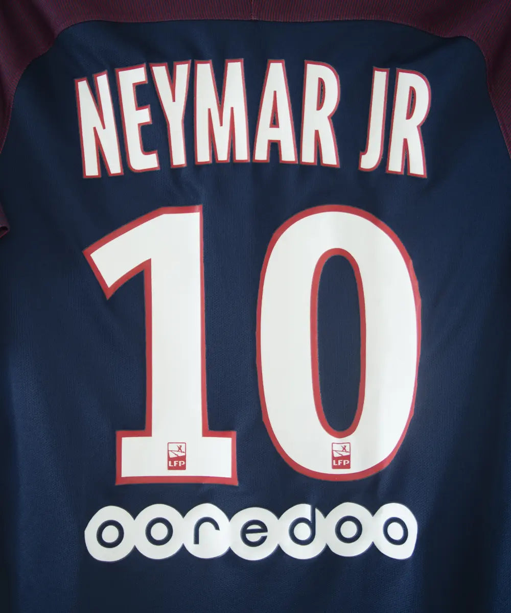 Maillot domicile bleu et rouge du psg de la saison 2017-2018. On peut retrouver l'équipementier nike et le sponsor fly emirates. Le maillot est floqué du numéro 10 Neymar