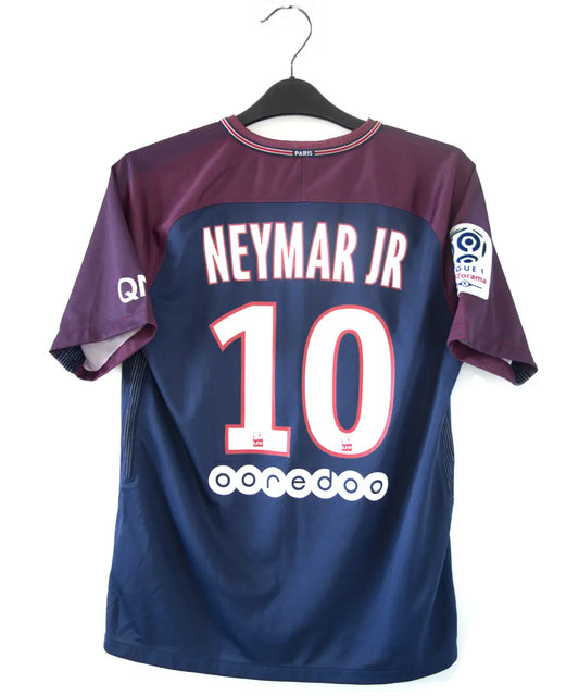 Maillot authentique du psg de la saison 2017-2018. Le maillot est de couleur bleu et rouge. On peut retrouver sur le maillot l'équipementier nike et le sponsor fly emirates et QNB. Le maillot est floqué du numéro 10 neymar. Sur cette photo on peut voir le flocage