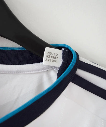 Etiquette d'authenticité du maillot domicile du real madrid de la saison 2012-2013. L'étiquette comporte les numéros X21987 AV1001