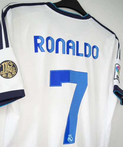 Maillot blanc et bleu du real madrid de la saison 2012-2013. On peut retrouver sur le maillot le sponsor bwin et l'équipementier adidas. Le maillot porte aussi le patch des 110 ans du real et le patch de la LFP. Sur cette photo on peut voir le flocage de côté du maillot du numéro 7 cristiano ronaldo
