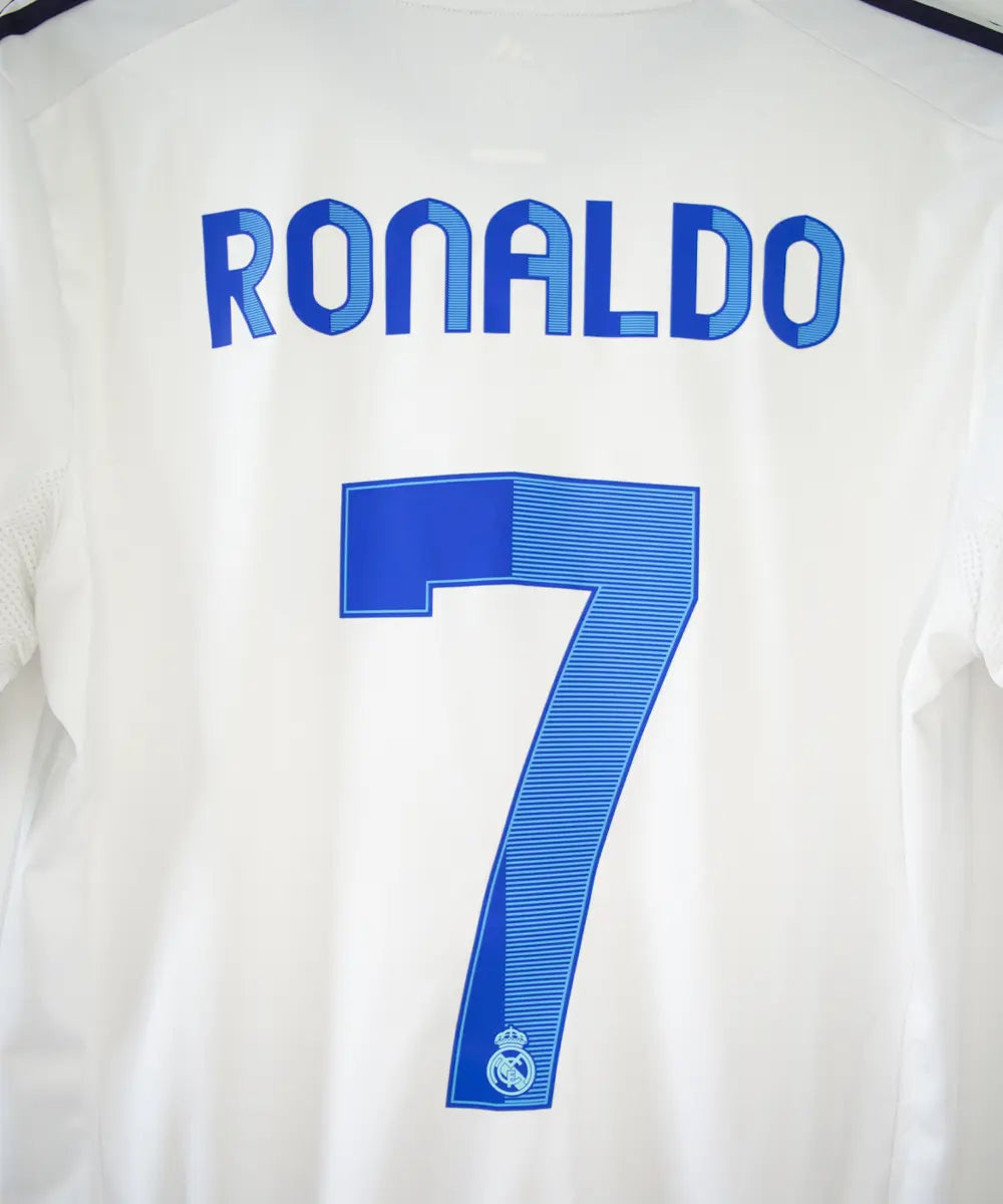 Maillot blanc et bleu du real madrid de la saison 2012-2013. On peut retrouver sur le maillot le sponsor bwin et l'équipementier adidas. Le maillot porte aussi le patch des 110 ans du real et le patch de la LFP. Sur cette photo on peut voir le flocage de près du maillot du numéro 7 cristiano ronaldo