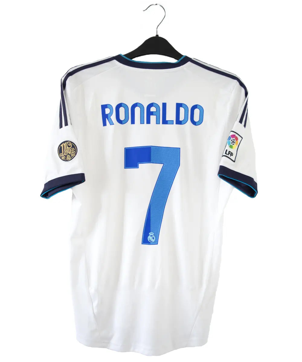 Maillot blanc et bleu du real madrid de la saison 2012-2013. On peut retrouver sur le maillot le sponsor bwin et l'équipementier adidas. Le maillot porte aussi le patch des 110 ans du real et le patch de la LFP. Sur cette photo on peut voir le flocage du maillot du numéro 7 cristiano ronaldo