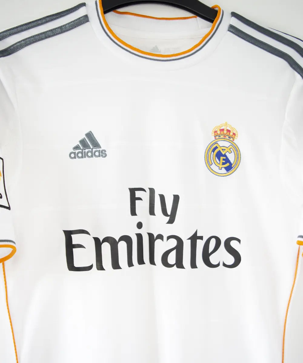 Maillot domicile blanc du réal madrid de la saison 2013-2014. On peut retrouver l'équipementier adidas et le sponsor fly emirates. Le maillot est floqué du numéro 7 Ronaldo