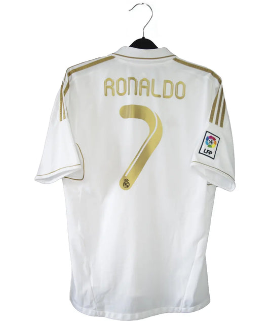 Maillot domicile du real madrid de couleur blanc et or de la saison 2011-2012. On peut retrouver l'équipementier adidas et le sponsor bwin. Le maillot est floqué du numéro 7 Cristiano Ronaldo. L'étiquette du maillot comporte les numéro V13659