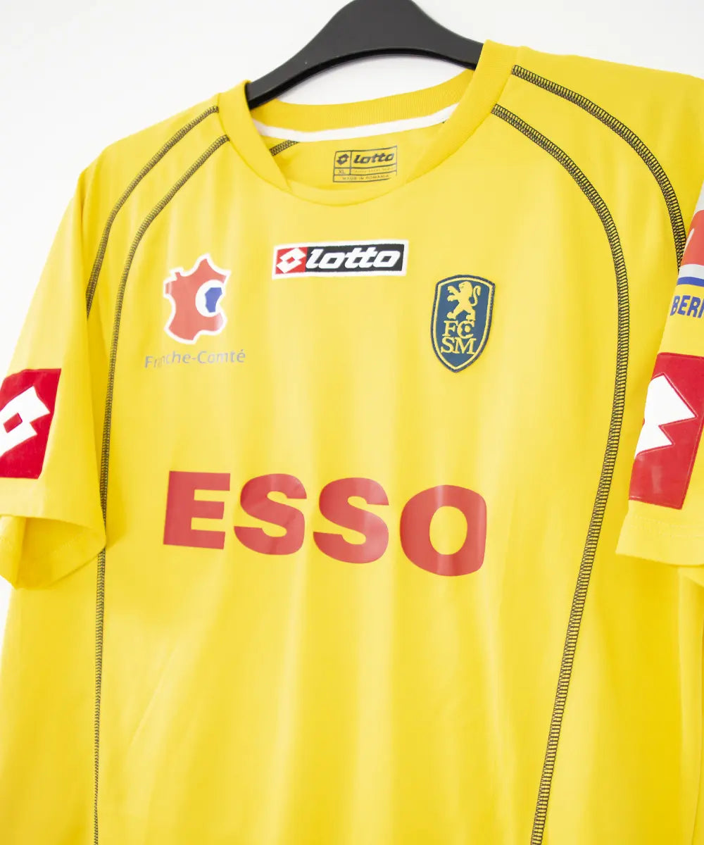 Maillot domicile jaune de sochaux de la saison 2004 2005. On peut retrouver l'équipementier lotto et le sponsor esso. Le maillot est floqué du numéro 26 Ménez