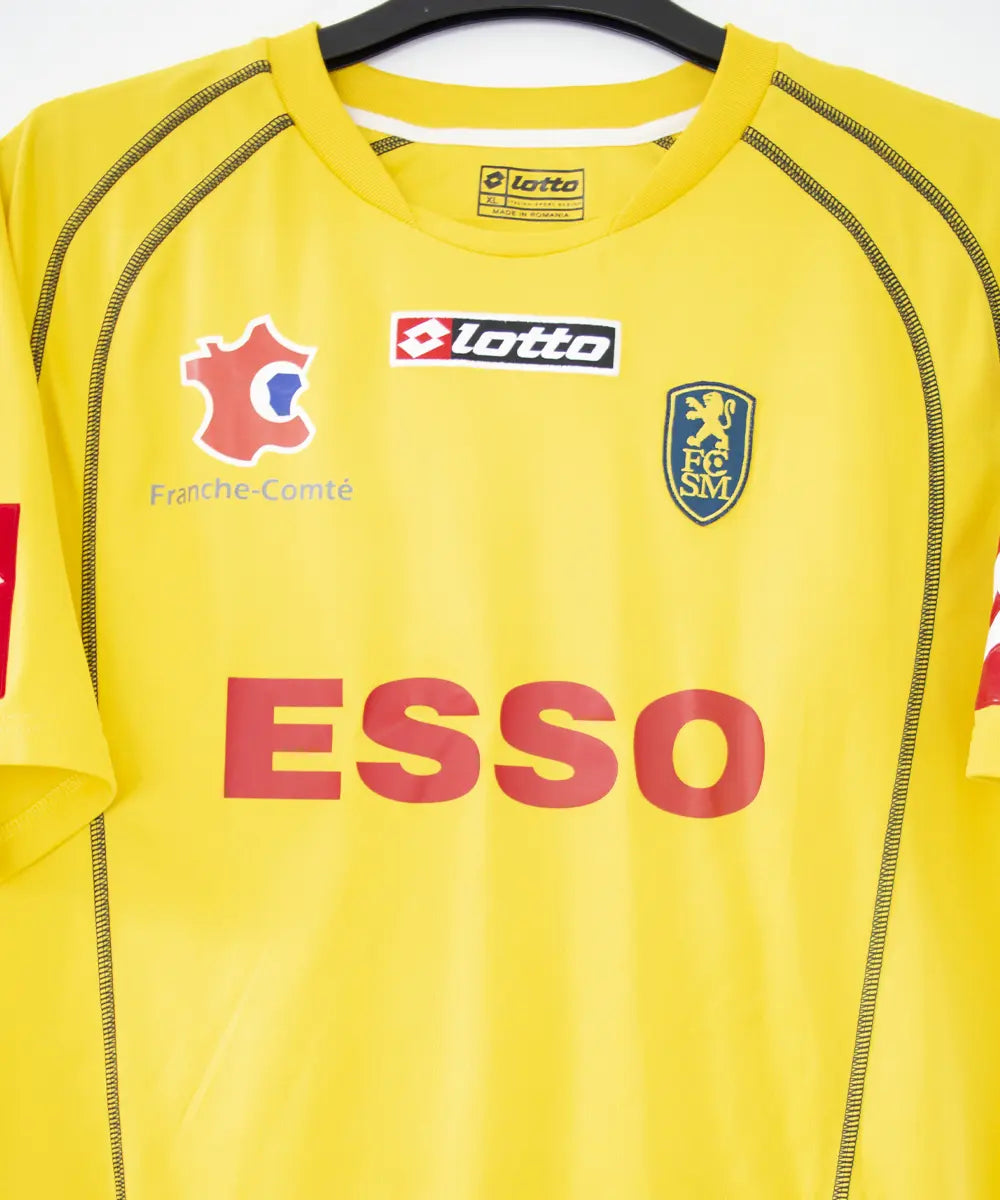 Maillot domicile jaune de sochaux de la saison 2004 2005. On peut retrouver l'équipementier lotto et le sponsor esso. Le maillot est floqué du numéro 26 Ménez