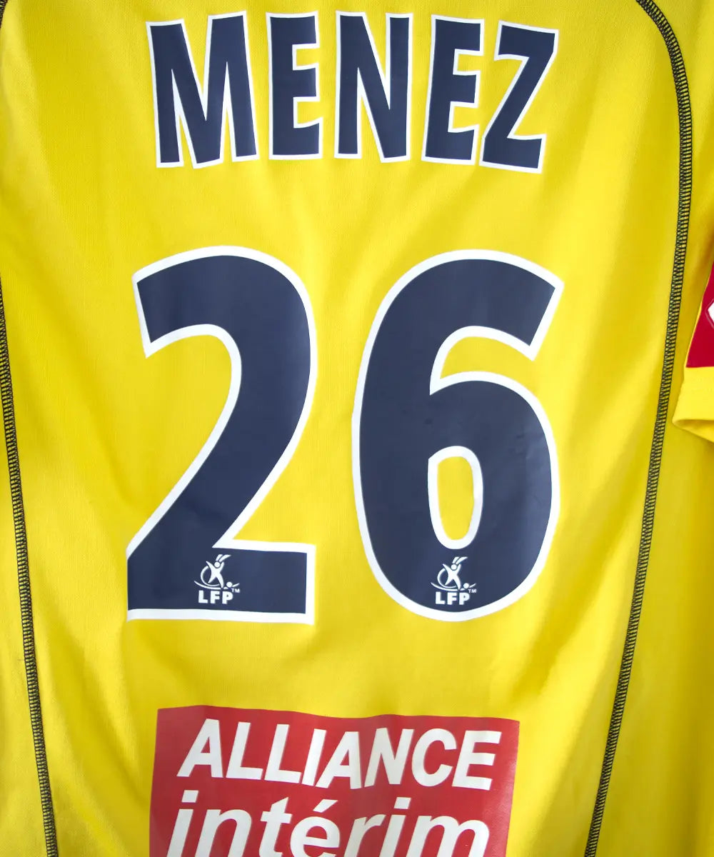 Maillot domicile jaune de sochaux de la saison 2004 2005. On peut retrouver l'équipementier lotto et le sponsor esso. Le maillot est floqué du numéro 26 Ménez