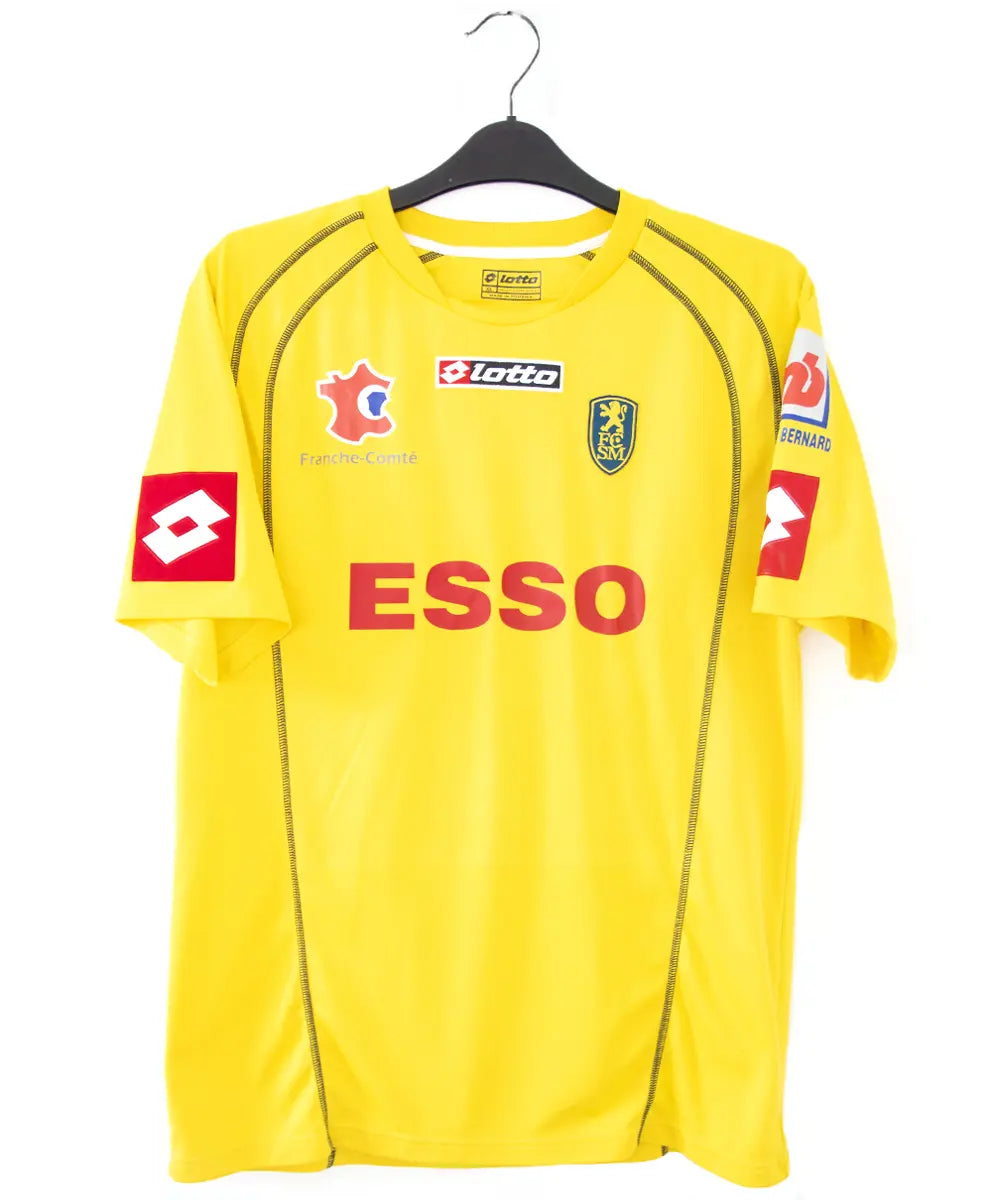 Maillot domicile jaune de sochaux de la saison 2004 2005. On peut retrouver l'équipementier lotto et le sponsor esso. Le maillot est floqué du numéro 26 Ménez