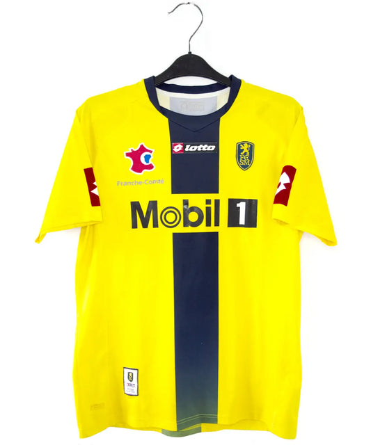 Maillot domicile du Sochaux Montbéliard FC de couleur jaune et bleu de la saison 2008-2009. On peut retrouver l'équipementier Lotto et le sponsor Mobile 1. Le maillot est floqué du numéro 9 Mevlut Erding