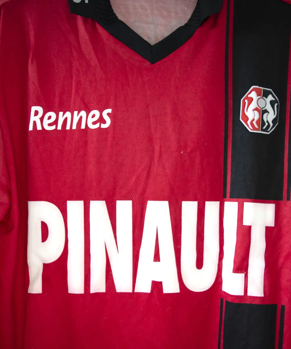 Maillot domicile du stade rennais porté lors de la saison 2000-2001 par Echouafni. Le maillot est de couleur rouge et noir. On peut retrouver l'équipementier asics et les sponsor Pinault et Finaref.