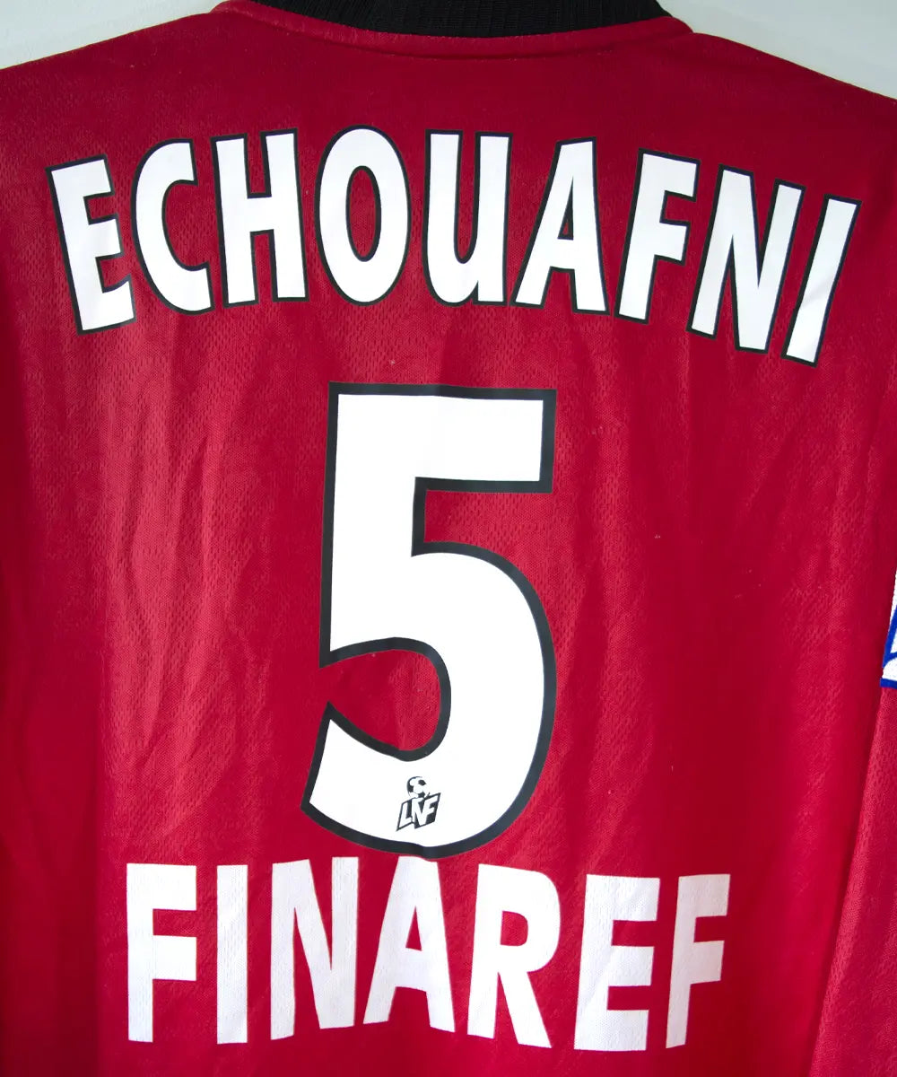 Maillot domicile du stade rennais porté lors de la saison 2000-2001 par Echouafni. Le maillot est de couleur rouge et noir. On peut retrouver l'équipementier asics et les sponsor Pinault et Finaref.