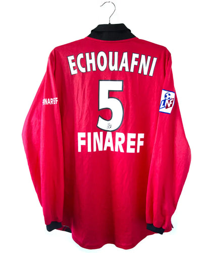 Maillot domicile du stade rennais porté lors de la saison 2000-2001 par Echouafni. Le maillot est de couleur rouge et noir. On peut retrouver l'équipementier asics et les sponsor Pinault et Finaref.