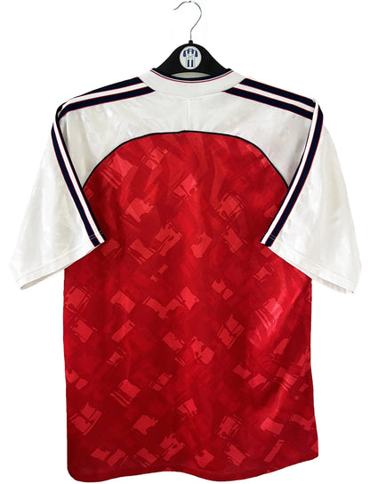 Maillot de foot vintage domicile rouge et blanc d'arsenal de la saison 1990/1992. On peut retrouver l'équipementier adidas et le sponsor JVC. Il s'agit d'un maillot authentique d'époque.