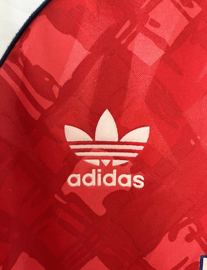 Maillot de foot vintage domicile rouge et blanc d'arsenal de la saison 1990/1992. On peut retrouver l'équipementier adidas et le sponsor JVC. Il s'agit d'un maillot authentique d'époque.