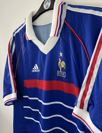 Maillot de foot vintage bleu, blanc et rouge de l'équipe de france 1998. On peut retrouver l'équipementier adidas. Il s'agit d'un maillot authentique d'époque