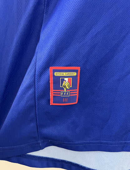 Maillot de foot vintage bleu, blanc et rouge de l'équipe de france 1998. On peut retrouver l'équipementier adidas. Il s'agit d'un maillot authentique d'époque