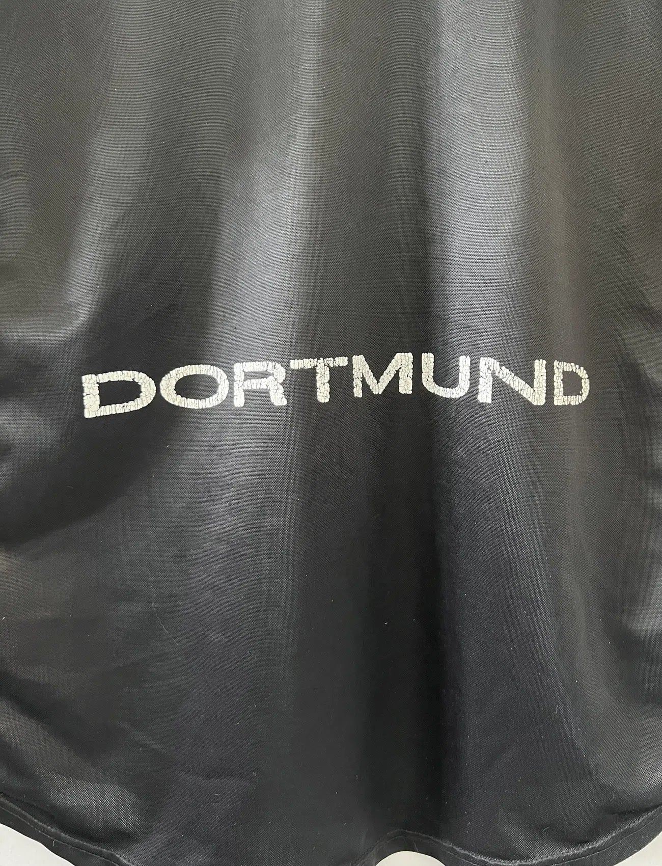 Maillot de foot vintage du Borussia Dortmund de la saison 1998/2000. Le maillot est de couleur noir et jaune. On peut retrouver l'équipementier nike et le sponsor s.Oliver. Le maillot possède l'étiquette d'authenticité F8-PKH. Il s'agit d'un maillot authentique d'époque.
