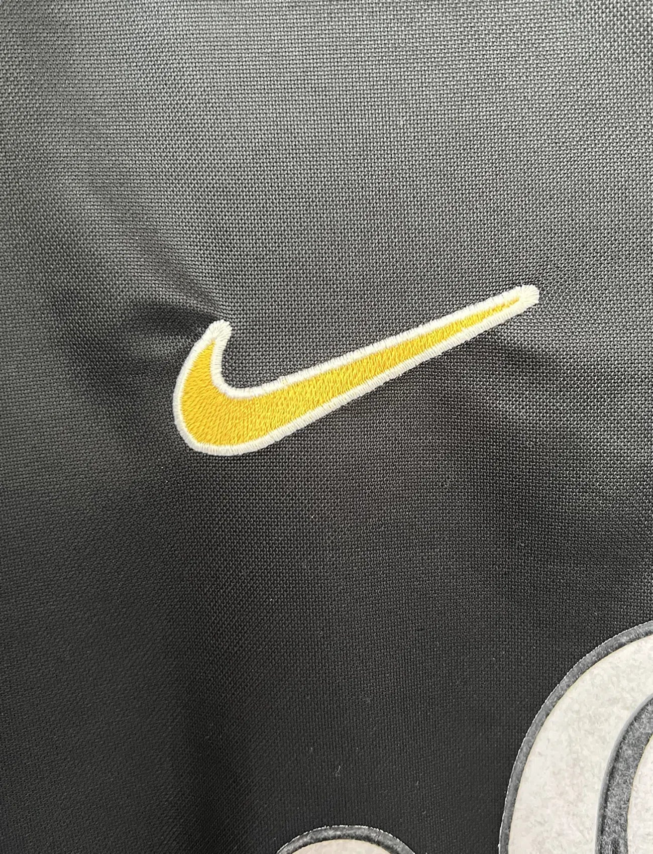 Maillot de foot vintage du Borussia Dortmund de la saison 1998/2000. Le maillot est de couleur noir et jaune. On peut retrouver l'équipementier nike et le sponsor s.Oliver. Le maillot possède l'étiquette d'authenticité F8-PKH. Il s'agit d'un maillot authentique d'époque.