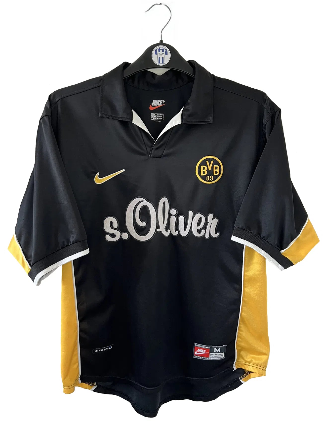 Maillot de foot vintage du Borussia Dortmund de la saison 1998/2000. Le maillot est de couleur noir et jaune. On peut retrouver l'équipementier nike et le sponsor s.Oliver. Le maillot possède l'étiquette d'authenticité F8-PKH. Il s'agit d'un maillot authentique d'époque.