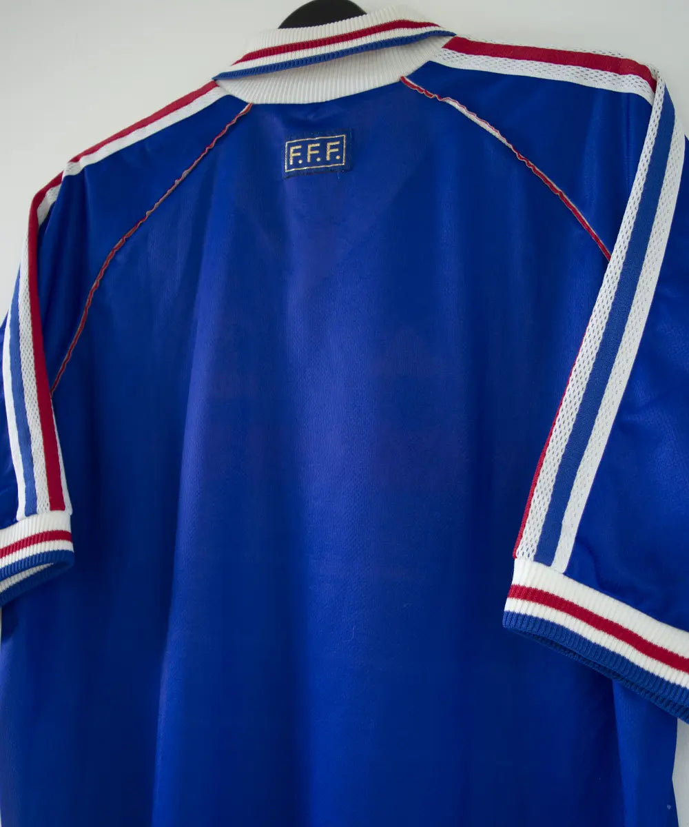 Maillot de l'équipe de france 1998 domicile de couleur bleu blanc et rouge. Le maillot est signé zinedine zidane. On peut retrouver l'équipementier adidas sur le maillot