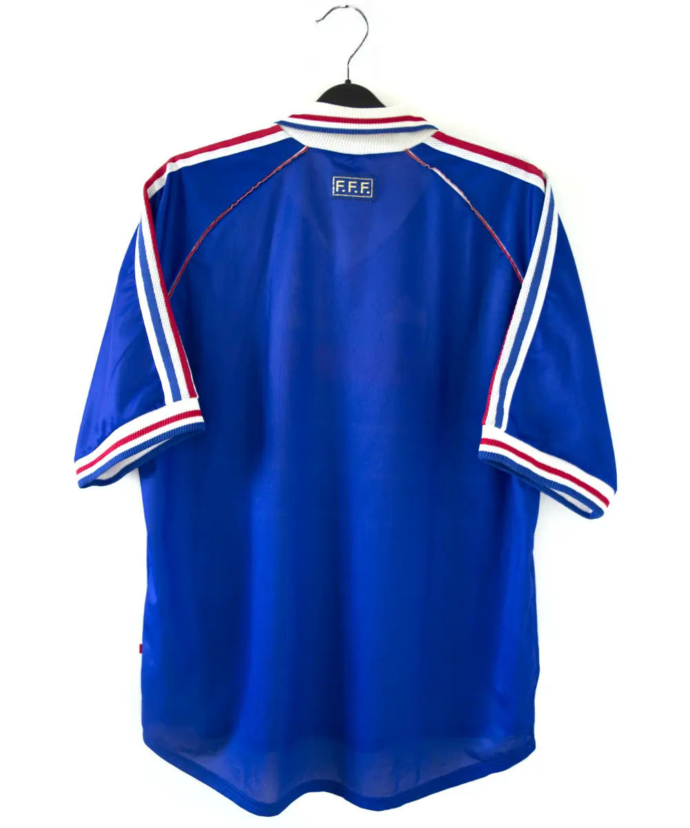 Maillot de l'équipe de france 1998 domicile de couleur bleu blanc et rouge. Le maillot est signé zinedine zidane. On peut retrouver l'équipementier adidas sur le maillot