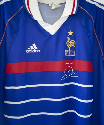Maillot de l'équipe de france 1998 domicile de couleur bleu blanc et rouge. Le maillot est signé zinedine zidane. On peut retrouver l'équipementier adidas sur le maillot