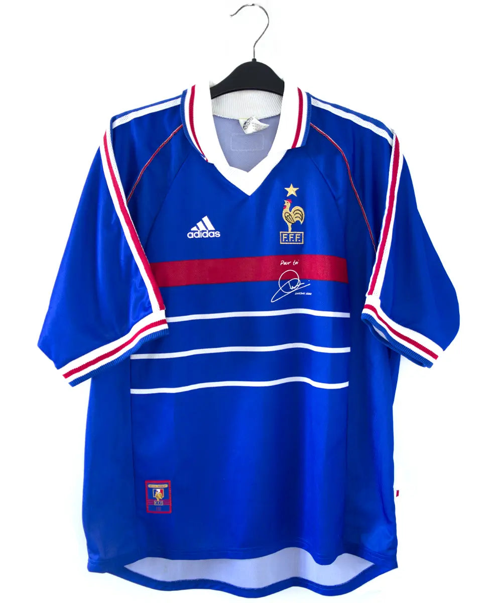 Maillot de l'équipe de france 1998 domicile de couleur bleu blanc et rouge. Le maillot est signé zinedine zidane. On peut retrouver l'équipementier adidas sur le maillot