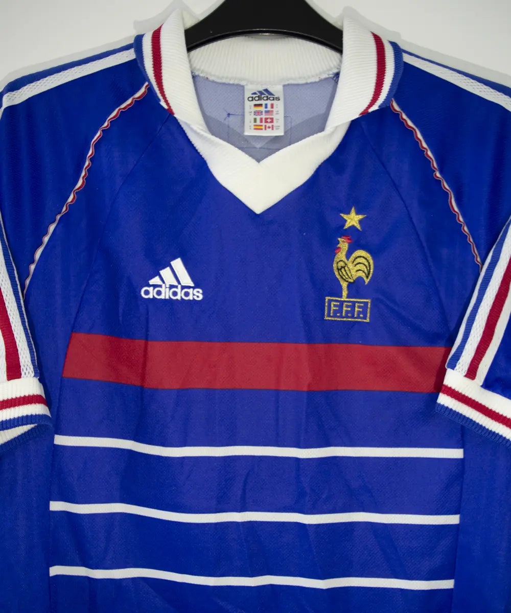 Maillot vintage bleu blanc rouge de l'équipe de france 1998. On peut retrouver l'équipementier adidas. Le maillot est floqué du numéro 10 Zinedine Zidane
