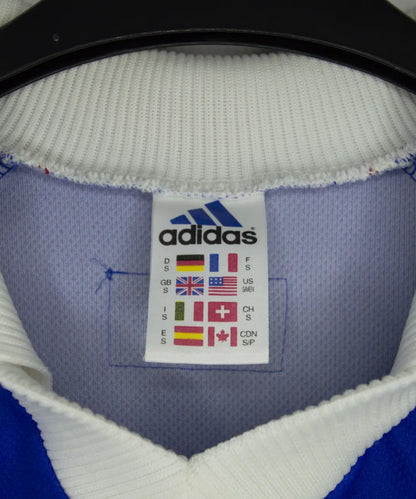 Maillot vintage bleu blanc rouge de l'équipe de france 1998. On peut retrouver l'équipementier adidas. Le maillot est floqué du numéro 10 Zinedine Zidane
