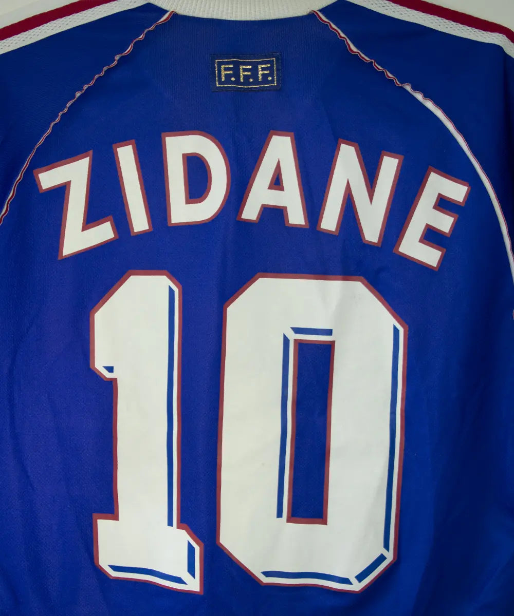 Maillot vintage bleu blanc rouge de l'équipe de france 1998. On peut retrouver l'équipementier adidas. Le maillot est floqué du numéro 10 Zinedine Zidane
