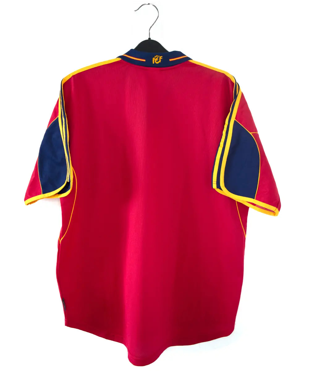 Maillot domicile de l'espagne de couleur rouge, bleu et jaune de 1999 à 2002. On peut retrouver l'équipementier adidas.
